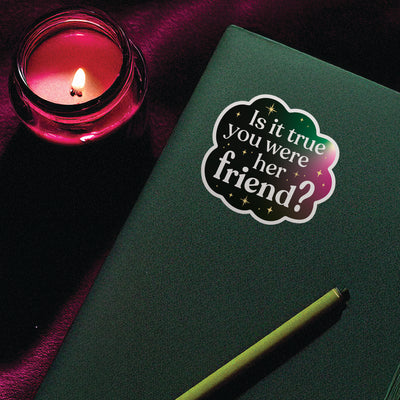Broadway-inspired vinyl sticker on a notebook with candle nearby, moody and magical aesthetic for queer theater fans